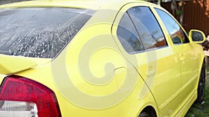 Man washing his car on the driveway.car wash at home.high pressure washer. Close up