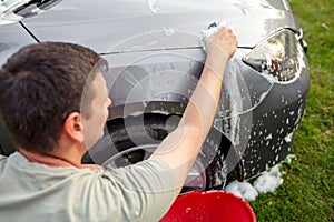 Man washing his car with sponge