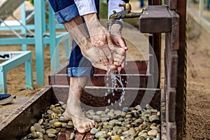 Man washing his feet on the sand beach.