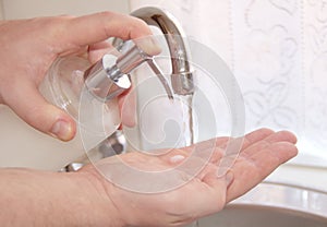 Man is washing his hands with liquid hand wash