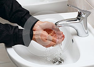 Man washing his hands in running water