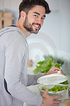 man washing lettuce ain kitchen