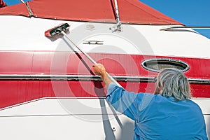 Man Washing Red and White Boat