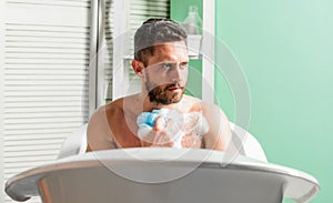 Man washing torso in bathroom. man wash muscular body with foam sponge. hygiene and health. Morning shower. stay clean