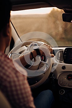 Man with watch driving a car