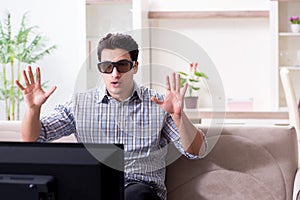 The man watching 3d tv at home