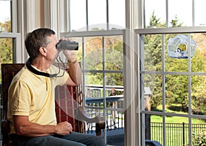 Man watching bird on feeder