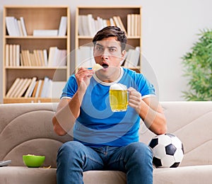 Man watching football at home sitting in couch