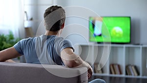 Man watching football match on big screen at home cheering his favorite team