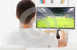 Man watching football or soccer game on tv at home
