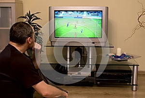 Muž sledovanie futbal na televízia 