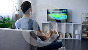 Man watching game on tv at home supporting one of soccer team, match result