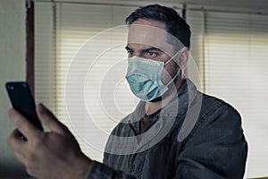 Man watching his cellphone with a health mask