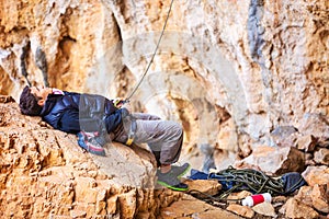 Man watching leading rock climber while belaying