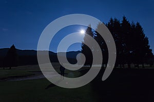 Man watching moon in golf course of Cansiglio Forest