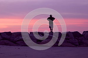 Hombre seguimiento rosa púrpura atardecer sobre el Playa 