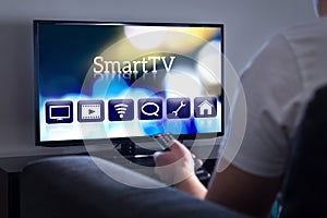 Man watching smart tv. Choosing movie or series from the menu. photo