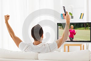 Man watching sport channel on tv and at home