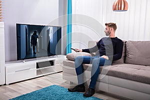 Man Watching Suspense Movie On Television photo