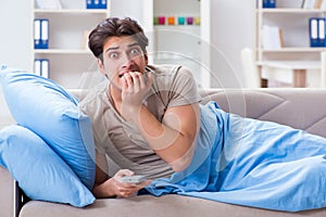 The man watching tv from bed holding remote control unit