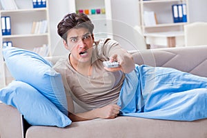 The man watching tv from bed holding remote control unit