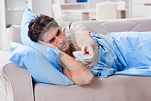 The man watching tv from bed holding remote control unit