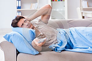 The man watching tv from bed holding remote control unit