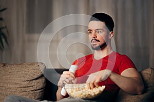 Man Watching TV Eating Pop Corn