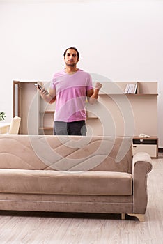 Young man watching tv at home during pandemic