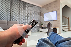 Man watching TV in living room with remote control