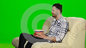 Man watching TV and smiling. Green screen