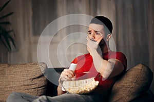 Man Watching TV While Snacking on Pop Corn