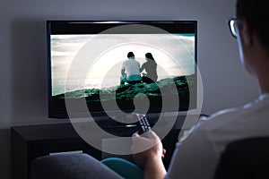 Man watching tv or streaming movie or series with smart tv photo