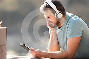 Man watching videos on tablet with headphones