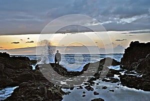 Man Watching Waves Crash at Sunset