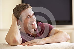 Man Watching Widescreen TV At Home