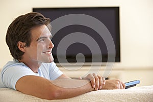 Man Watching Widescreen TV At Home