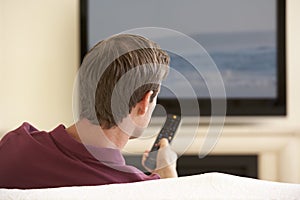 Man Watching Widescreen TV At Home