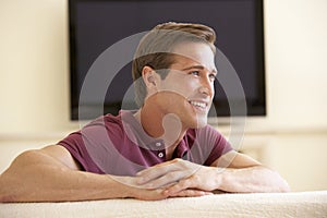 Man Watching Widescreen TV At Home