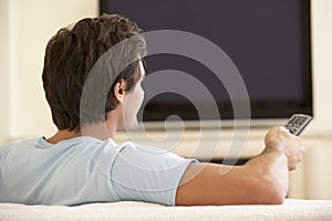 Man Watching Widescreen TV At Home