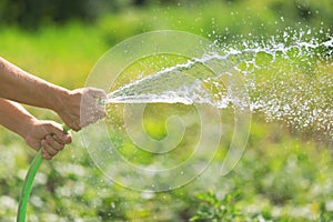 Man watering the garden from hose