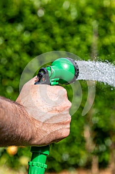 A man watering a garden with a hosepipe, during a dry summer in Sussex