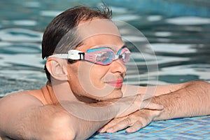 Man in watersport goggles swimming in pool