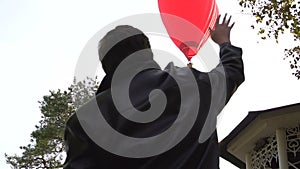 Man waves his hand to hot air balloon. Welcomes passengers