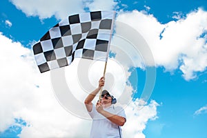 Man waving a checkered flag on a raceway