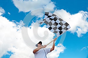 Man waving a checkered flag on a raceway