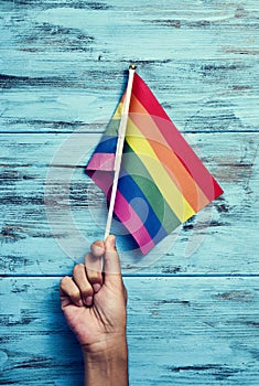 Man waving a small rainbow flag