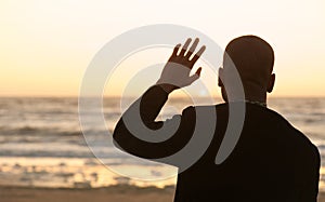 Man waving at the sunset