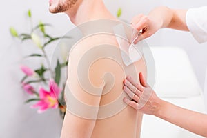 Man at waxing hair removal in beauty parlor