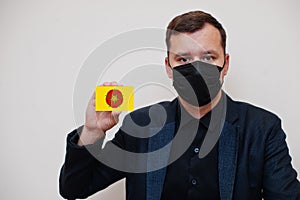 Man wear black formal and protect face mask, hold Lancashire flag card isolated on white background. United Kingdom counties of